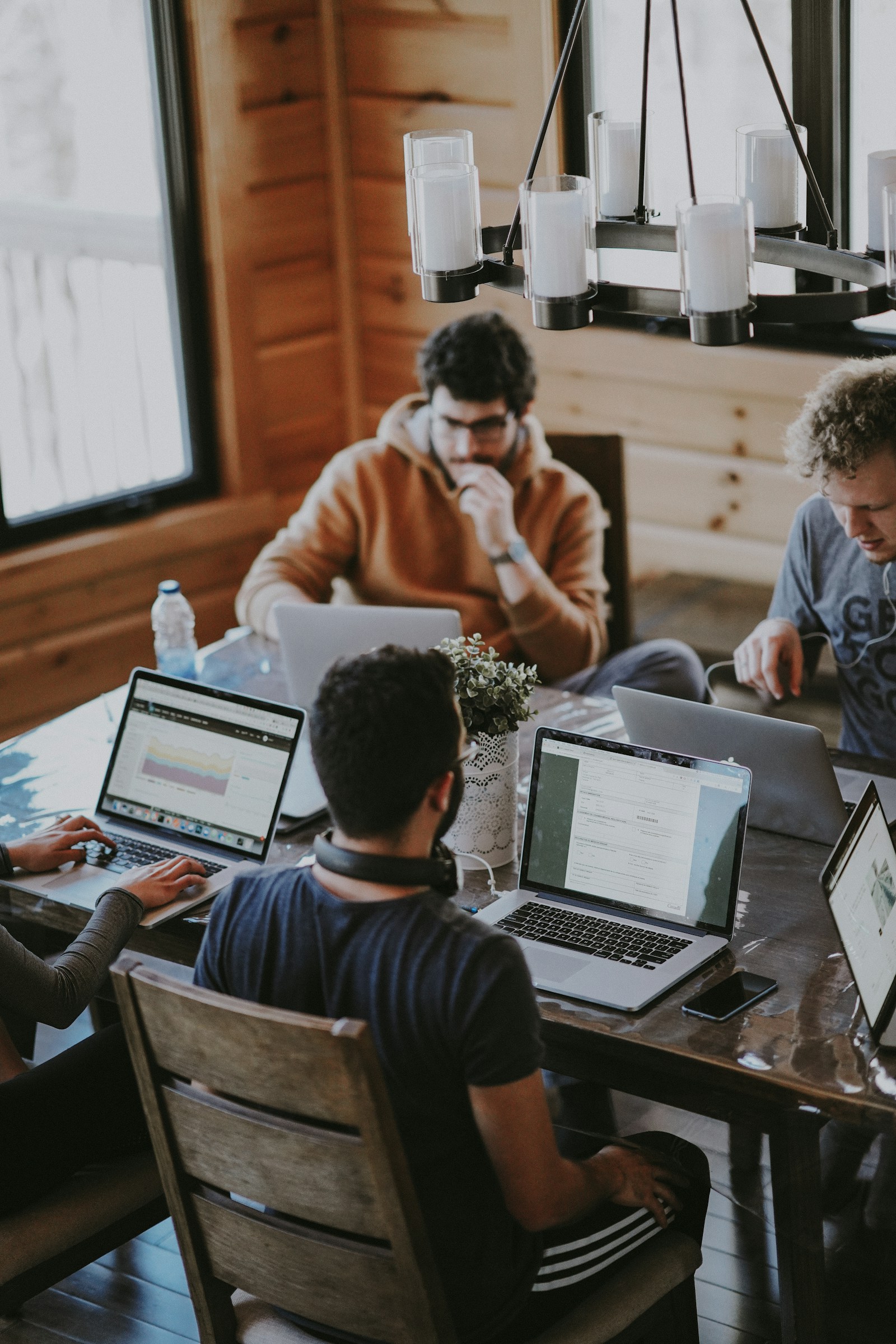 A small team gathered around laptops, working together.